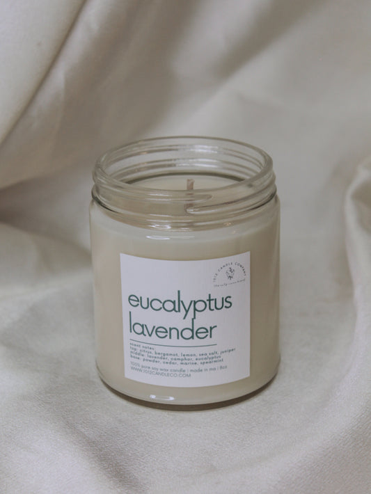 A soy wax candle in a clear jar labeled and scented like eucalyptus lavendar