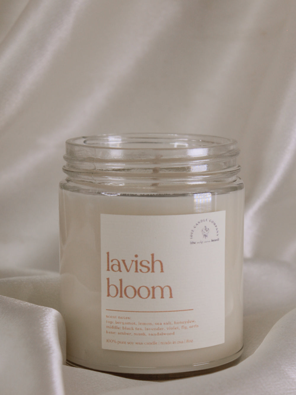 A spring scented, soy candle labeled lavish bloom in an 8oz clear jar