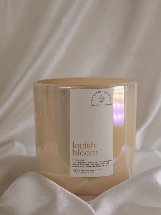 a spring scented, soy candle labeled Lavish Bloom in a yellow iridescent vessel