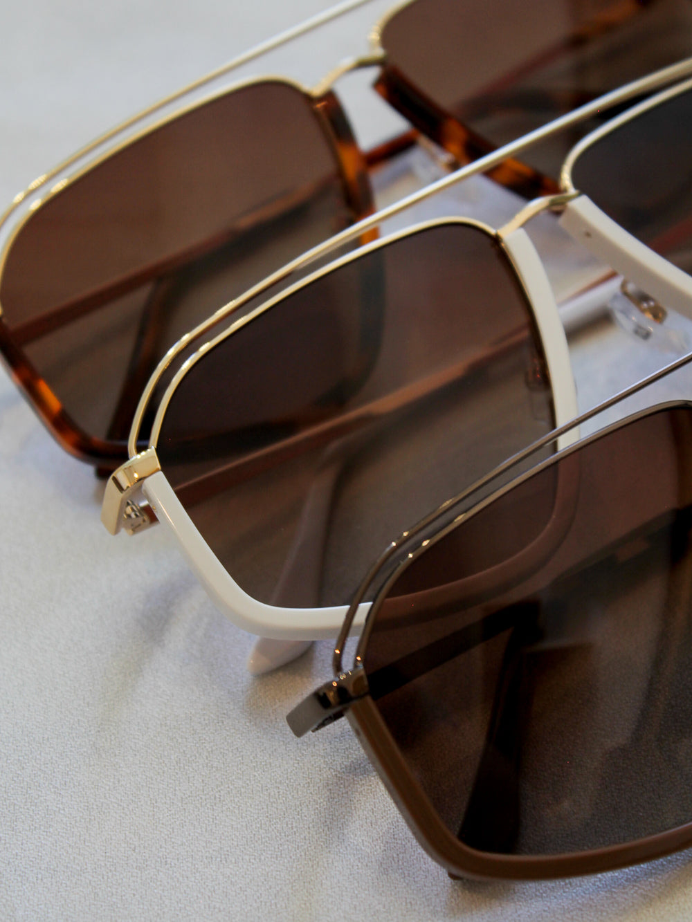 Oversized aviators by Eleventh Hour in three different color ways, tortoise, white and espresso brown