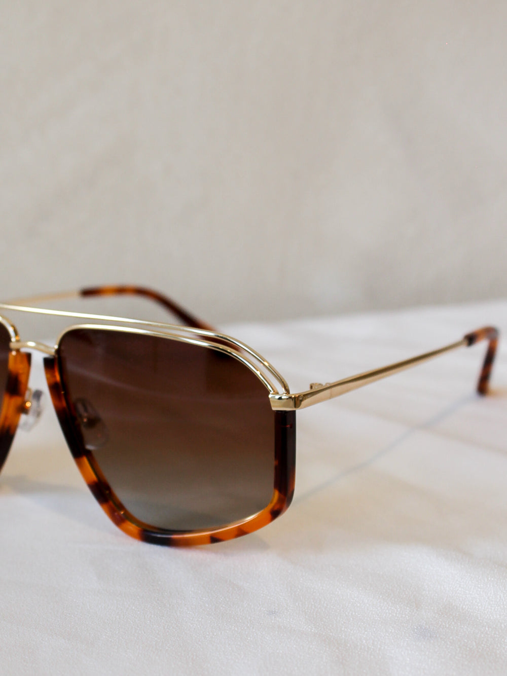 Sunglasses with tortoiseshell frame and brown lenses and gold accents