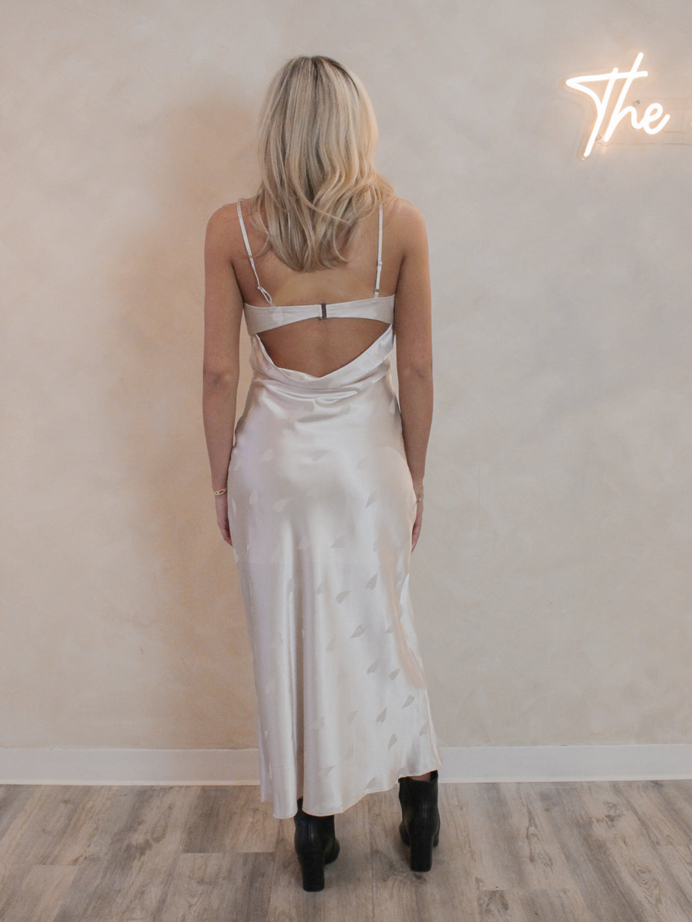 A cream satin midi dress with open back detail and subtle heart design