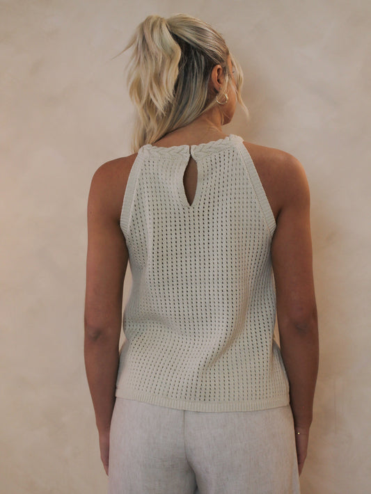 woman wearing a neutral tank with a braided halter neckline and keyhole back detail.