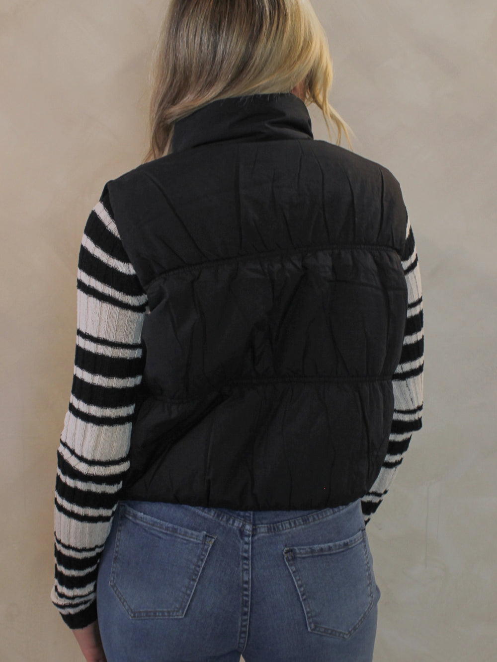 Woman wearing a black cropped puffer vest