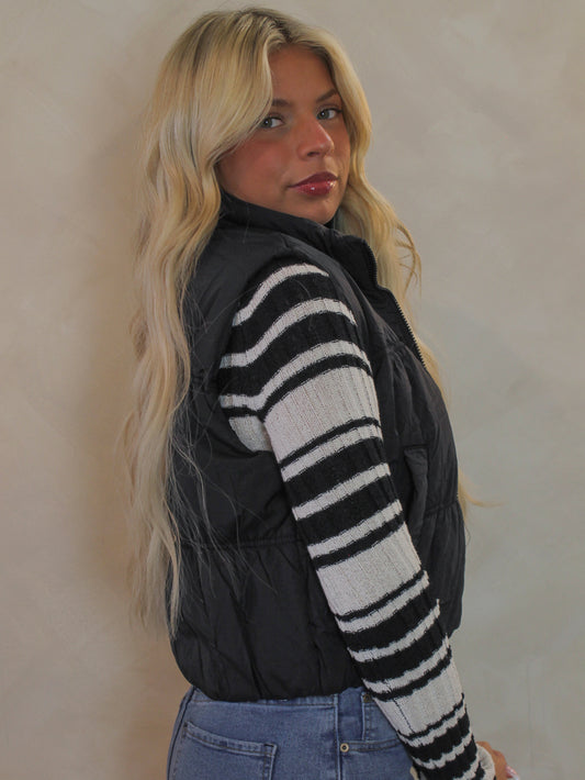 Woman wearing a black cropped puffer vest for fall and winter