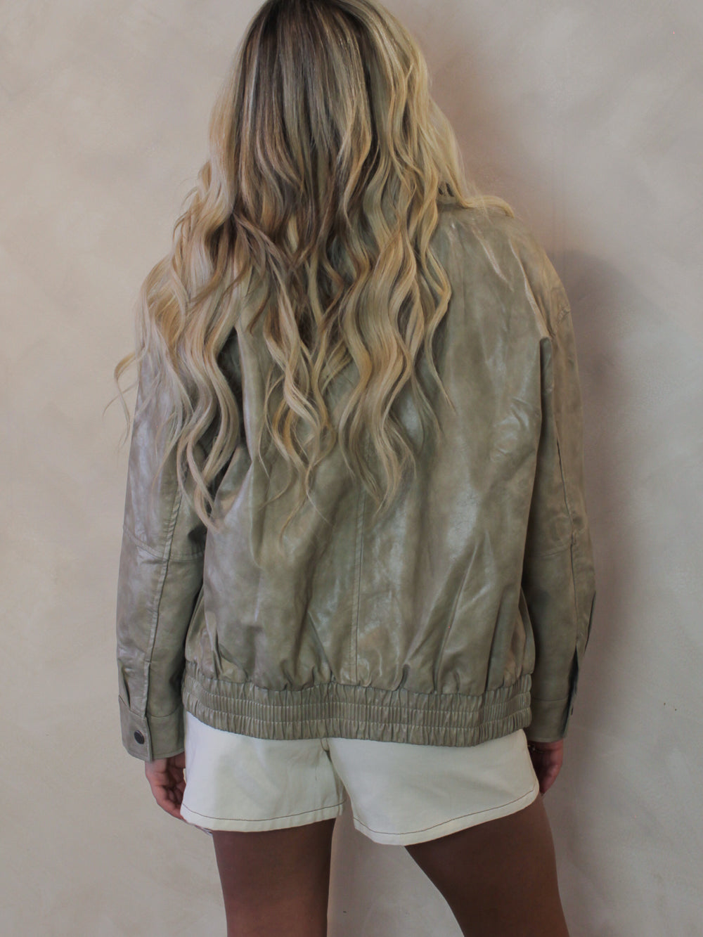 Back view of a woman wearing a worn textured leather jacket