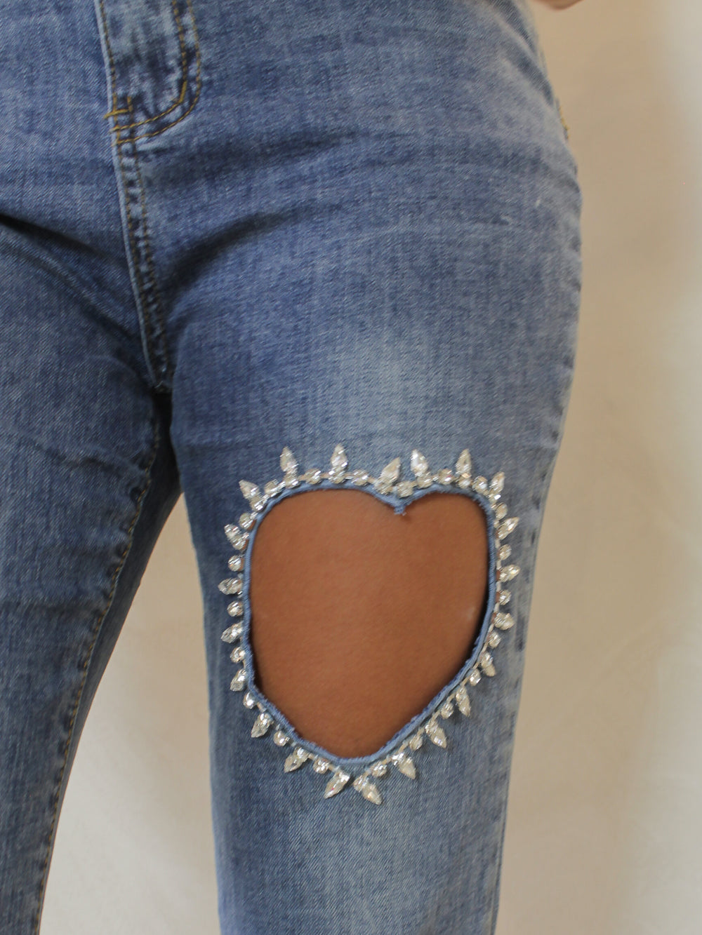 Medium wash denim with heart cutout and rhinestone details