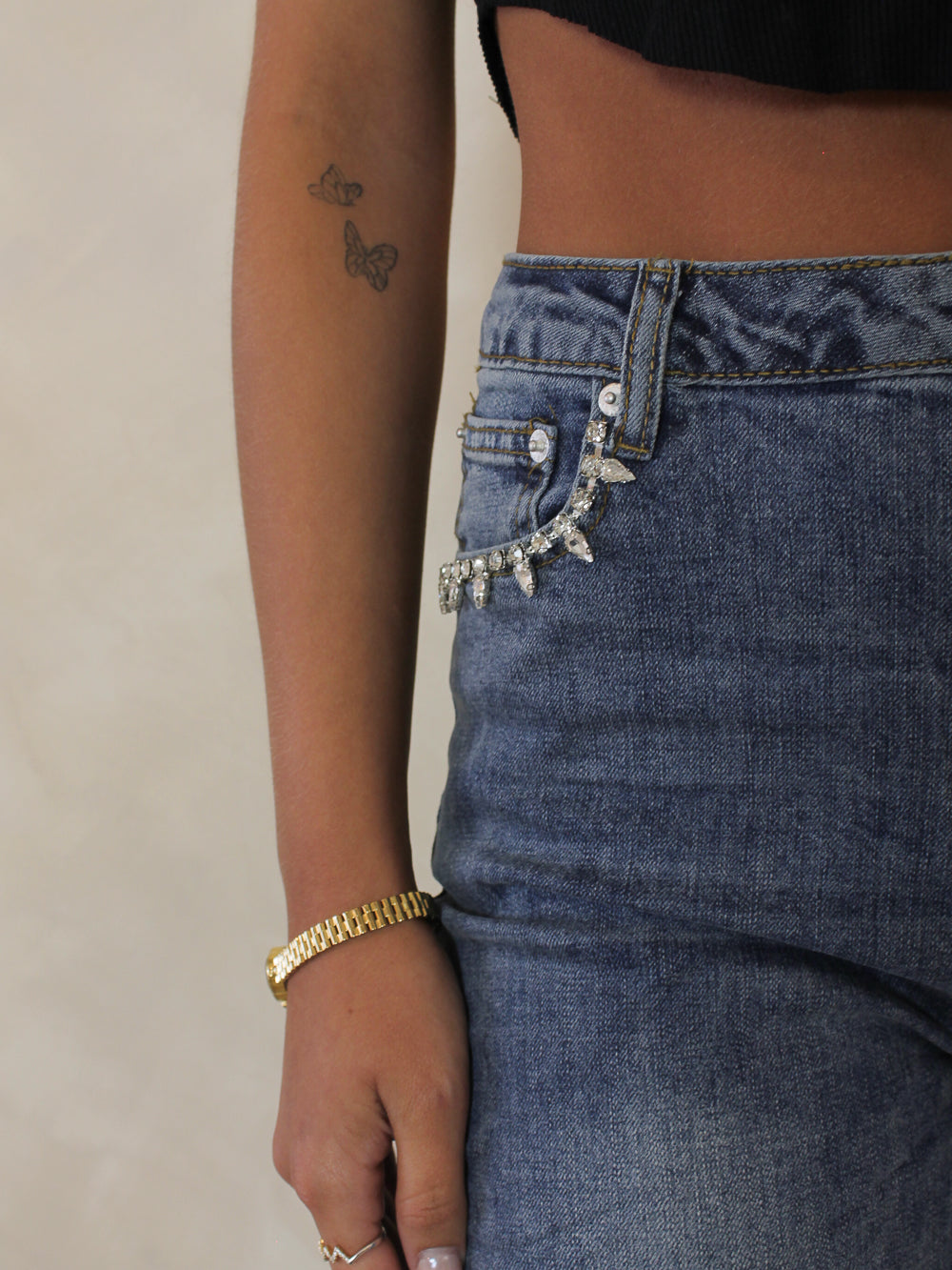 Medium wash denim with rhinestone details at the pocket