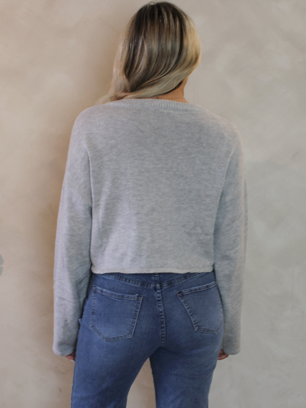 Woman wearing a grey knit sweater