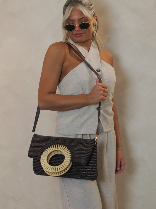 Model wearing a brown woven shoulder bag