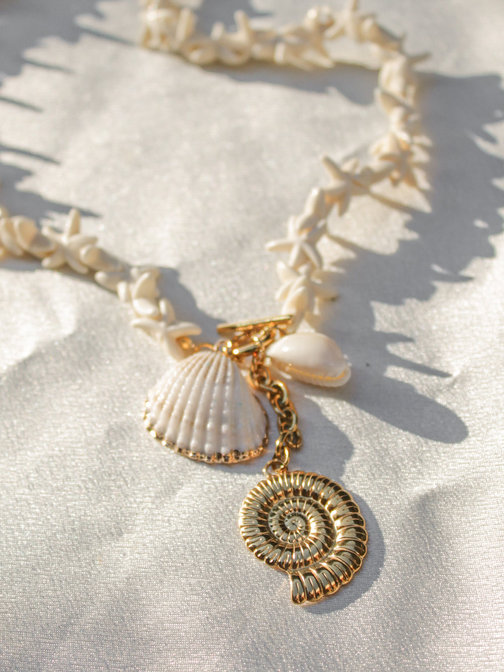detail view of a cluster of charms on a shell necklace