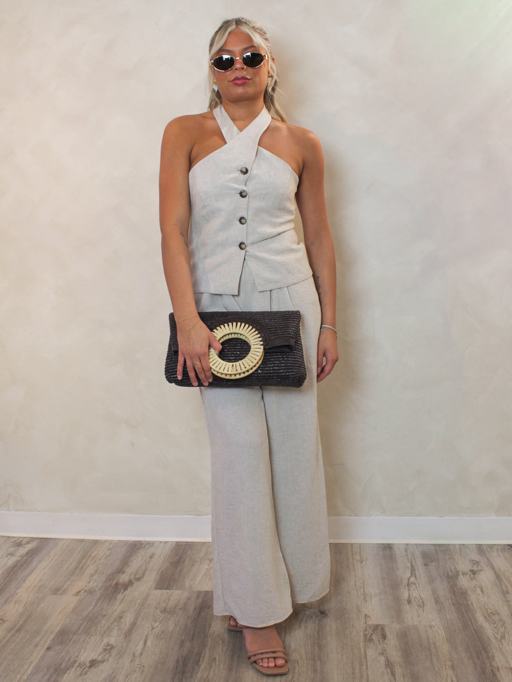 linen halter top and matching linen pants outfit styled with a woven clutch and gold accessories