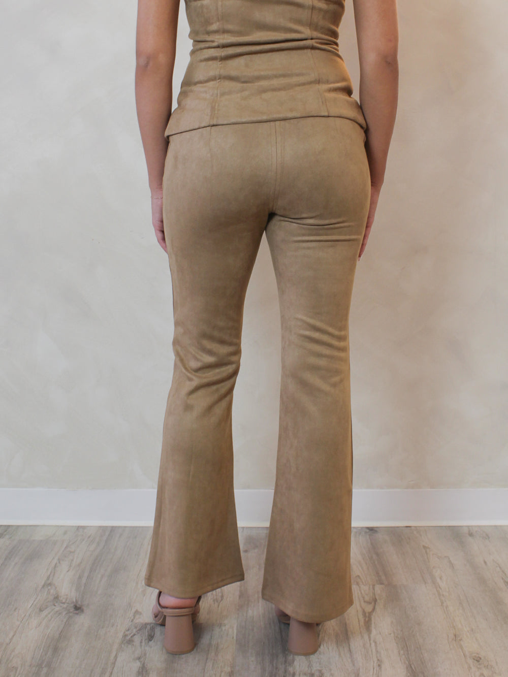 Woman wearing tan, suede, flared, low rise pants