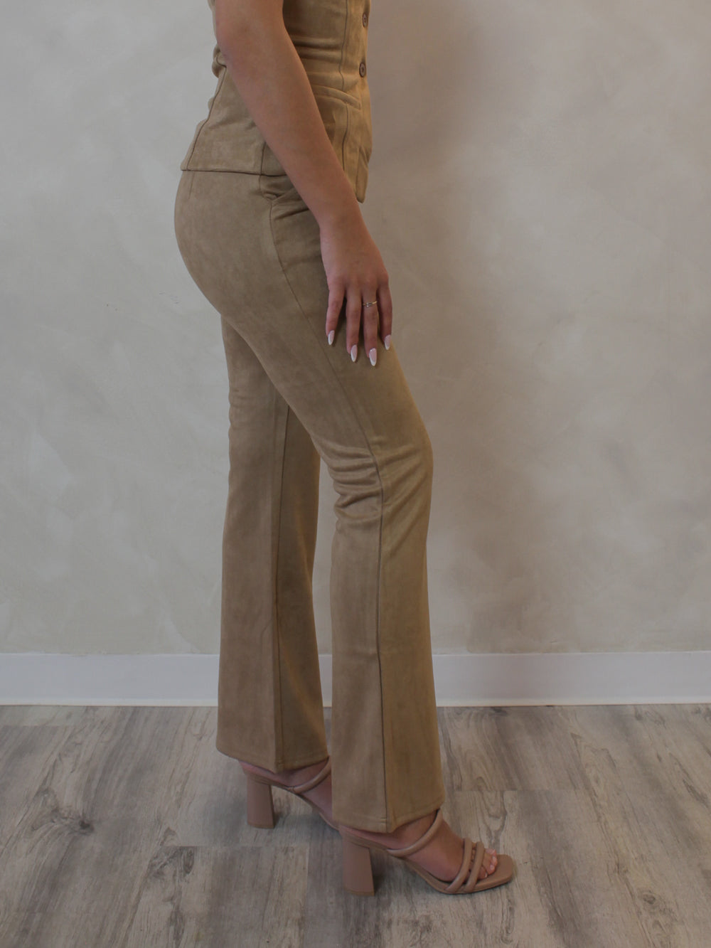 Woman wearing camel colored suede, flared pants