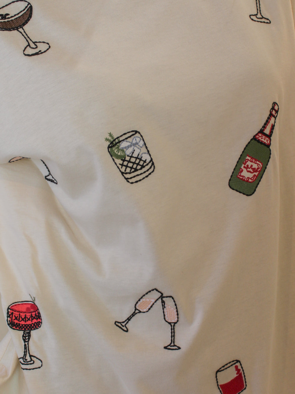 Embroidered cocktail theme graphics set on a comfy, oversized tee for women