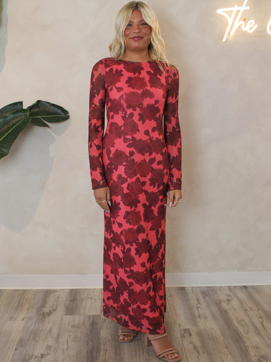 Woman wearing a mesh, red rose floral maxi dress with bell sleeves