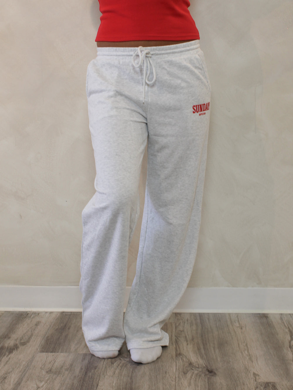 Womens gray sweatpants with red text that says 'Sunday Coffee Club'