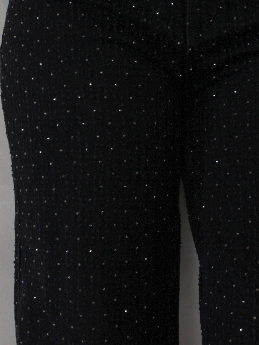 Close-up of black pants with gold sparkly rhinestone details