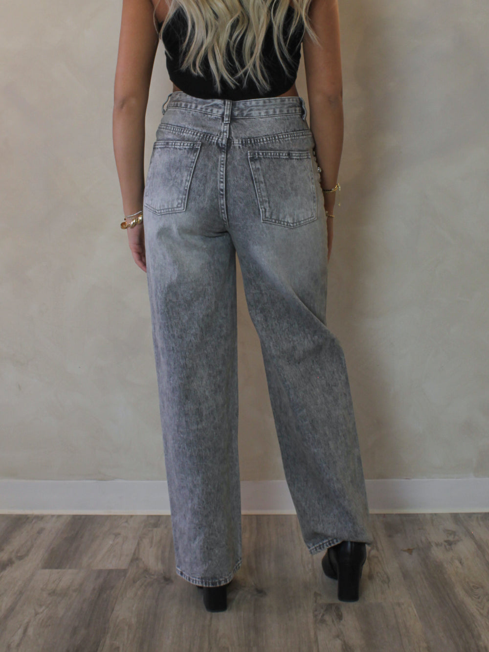 Model wearing a pair of gray straight leg denim