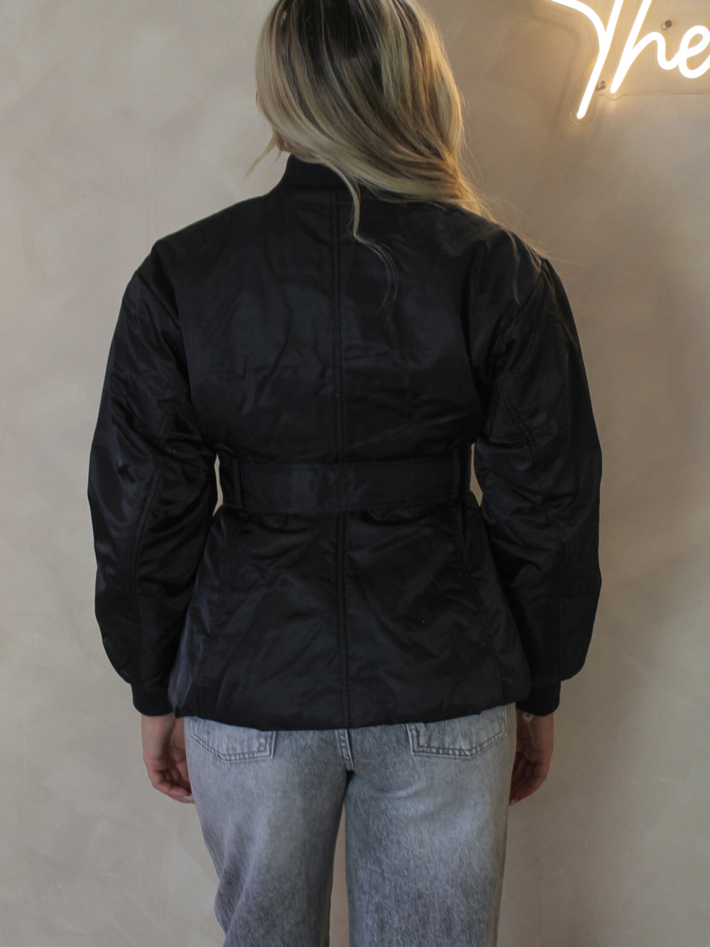 Model wearing a black belted nylon jacket