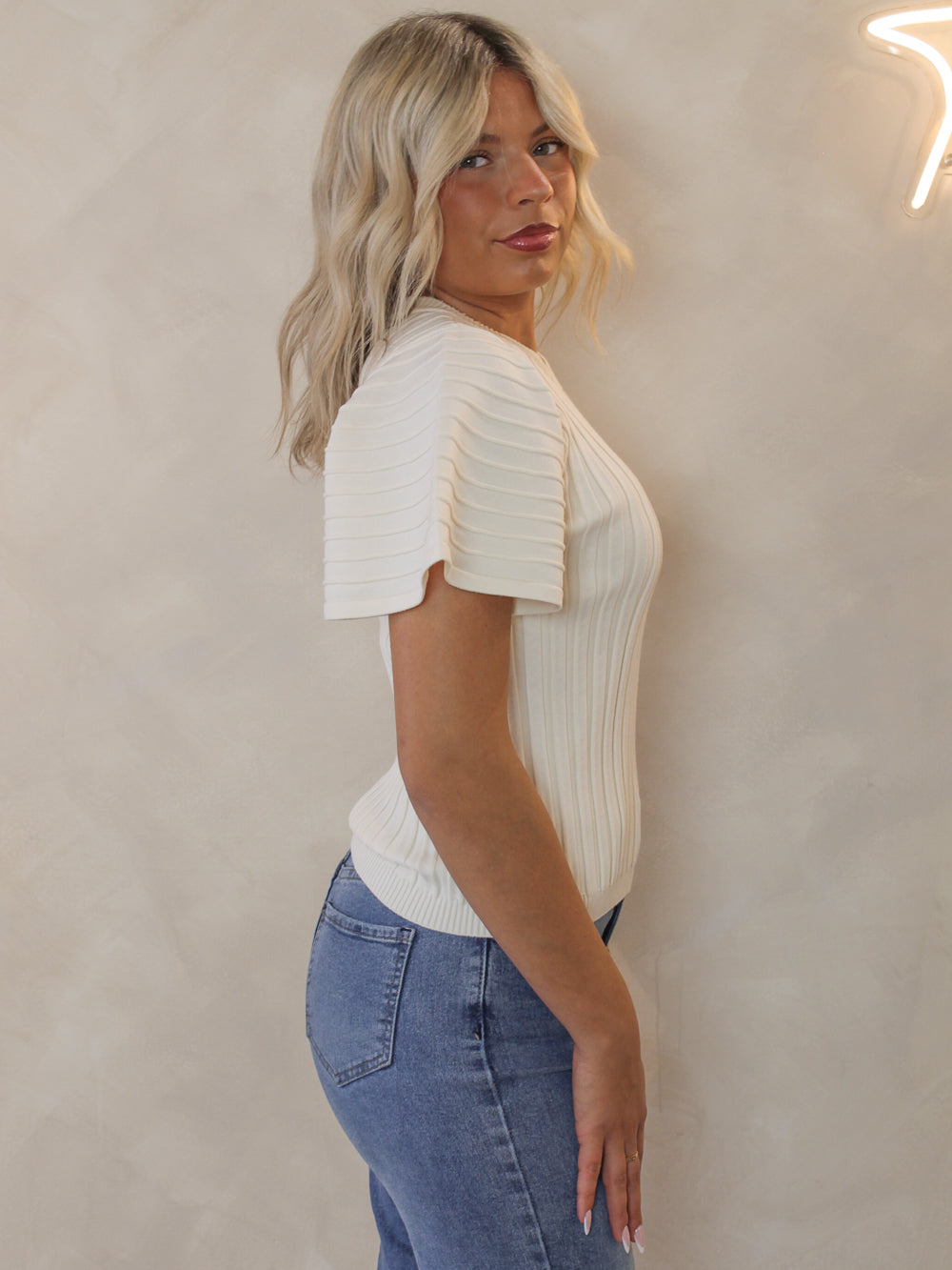 Woman wearing the Steve Madden Allie Sweater with short sleeves and a ribbed knit fabric