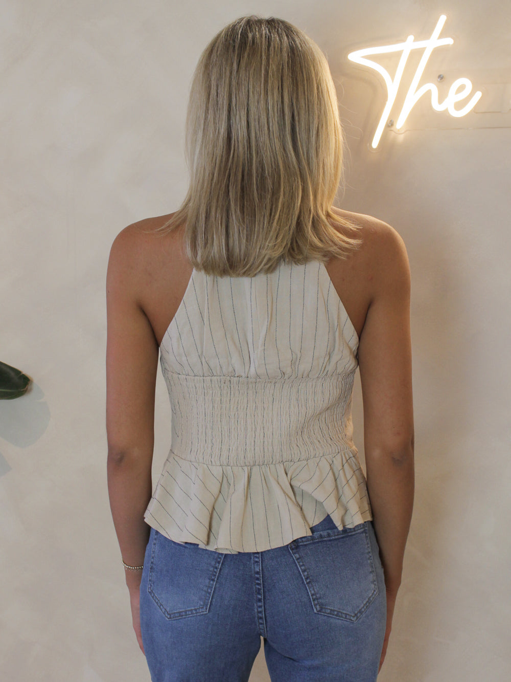 Beige, linen top with a smocked back and a peplum style hem