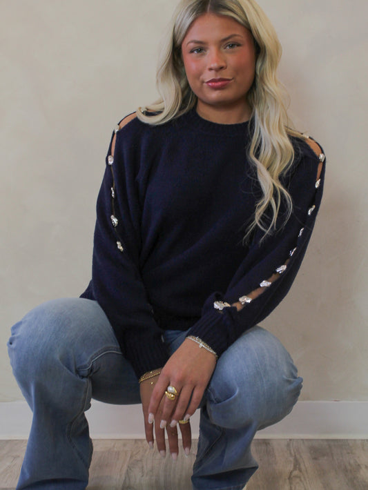 Model wearing a navy blue sweater with
silver details down the arm