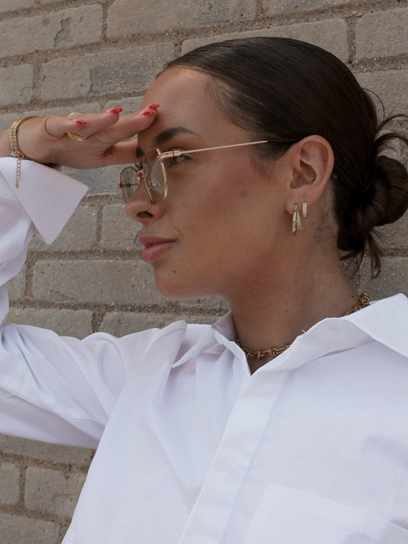Girl wearing Gold Sunglasses and Gold Jewelry