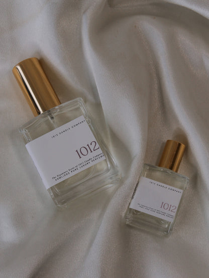 Two perfume bottles by 1012 Candle Co with gold tops and with scents of yuzu, bergamot, grapefruit, cashmere and more