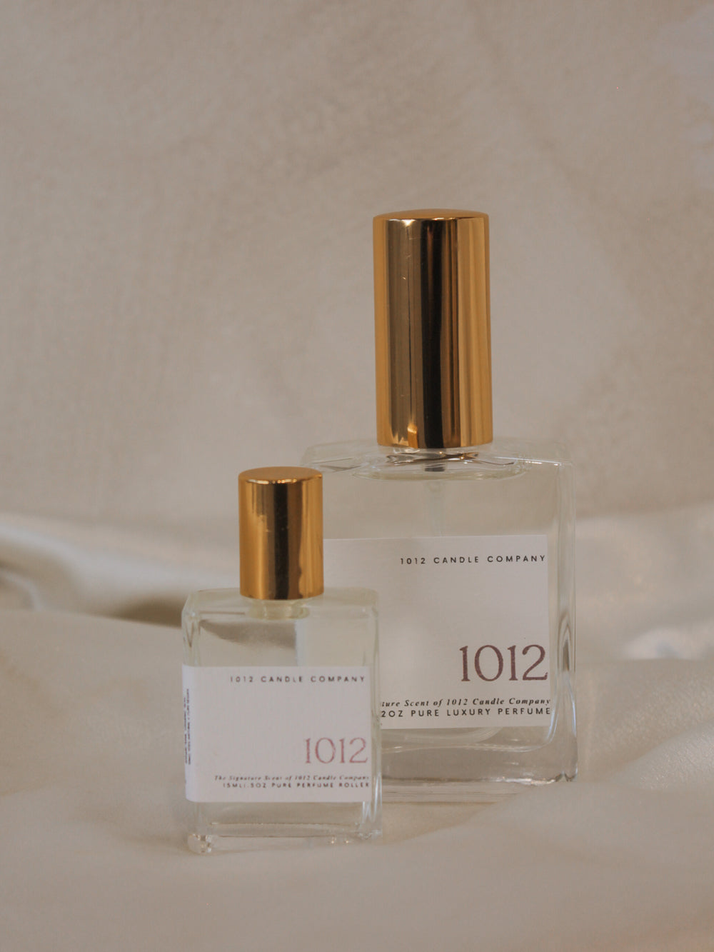 Two luxury organic perfumes in various size, clear glass bottles with gold tops by 1012 Candle Co 