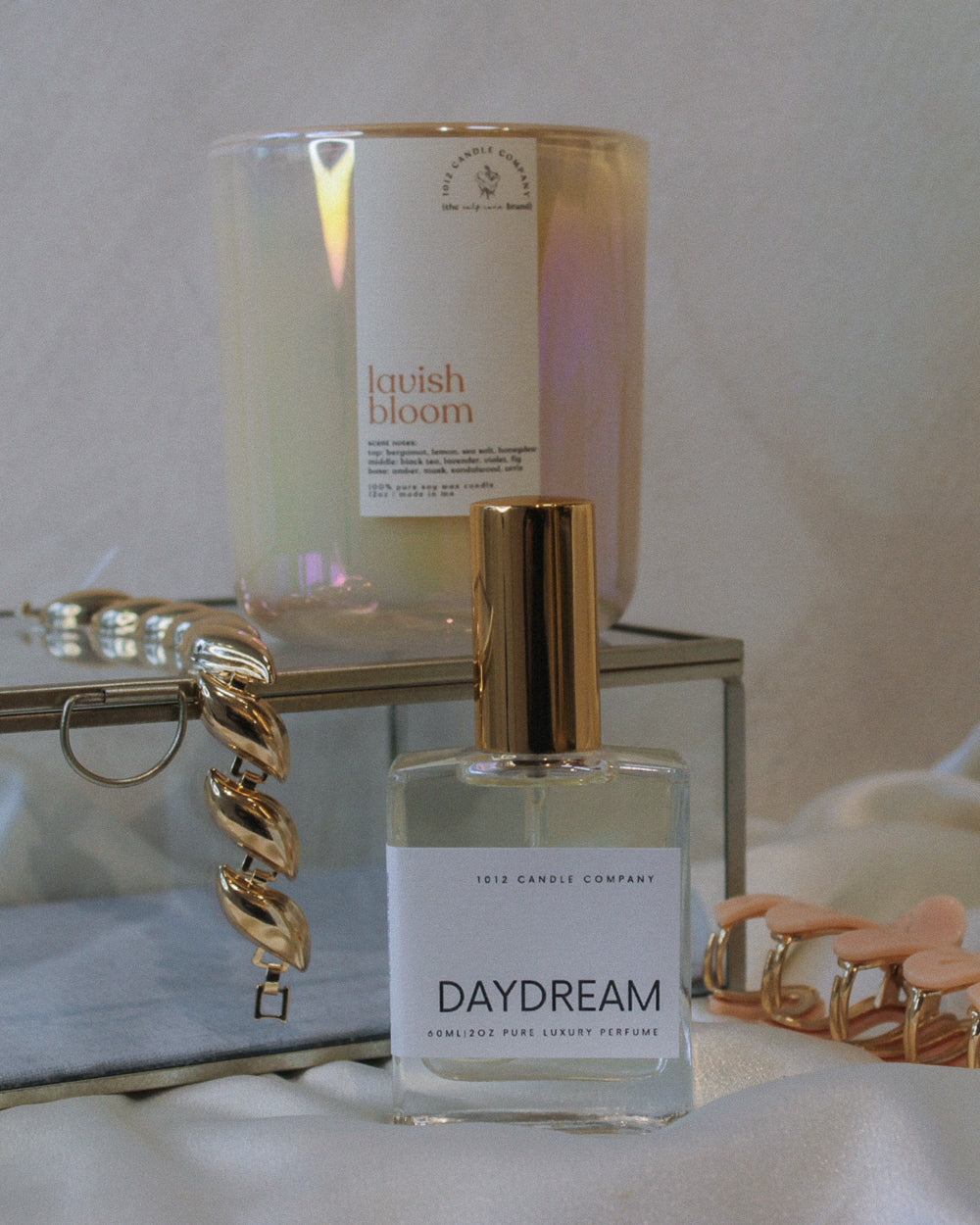 Perfume bottle labeled Daydream and candle labeled Lavish Bloom by 1012 Candle Co