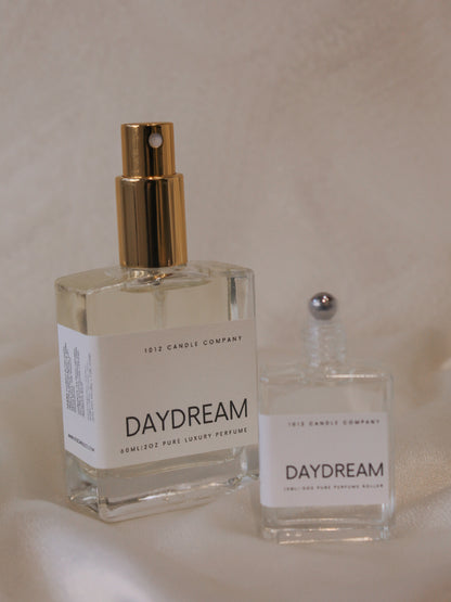 Two bottles of Daydream perfume by 1012 Candle Co in different size showing that one is a spray bottle and one is a rollerball 