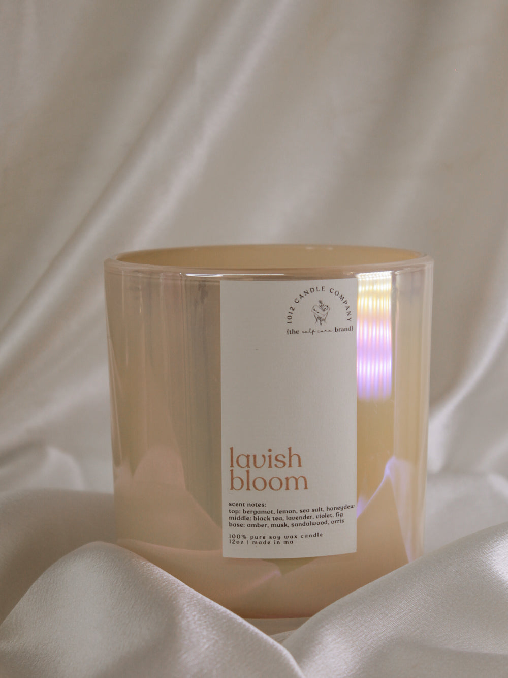 a spring scented, soy candle labeled Lavish Bloom in a yellow iridescent vessel 