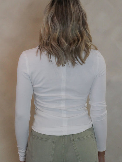 Back view of a white long sleeve top on a young woman