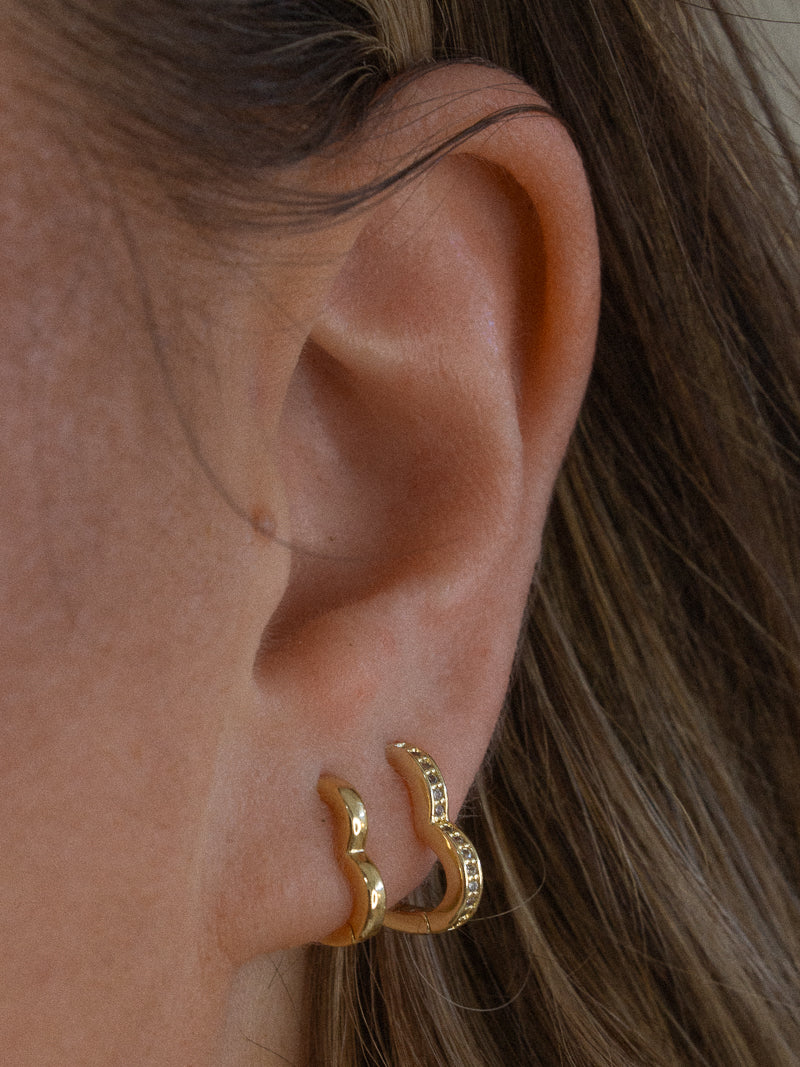 Girl wearing gold heart hoop earrings