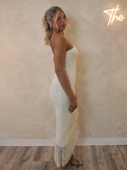 Woman wearing a one shoulder dress with a fringe bottom