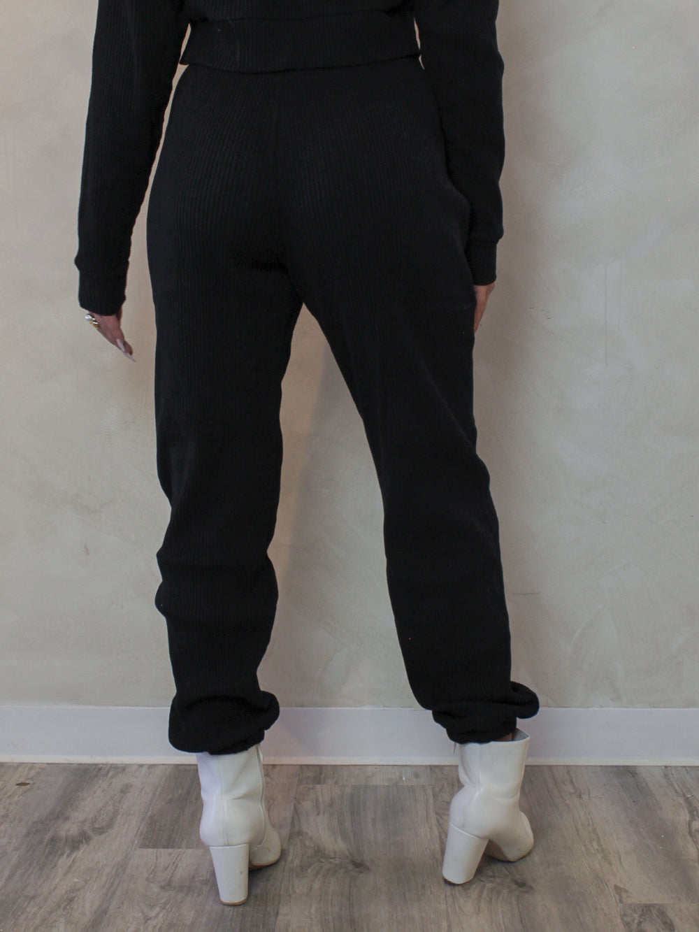 Model wearing a pair of black, ribbed, jogger sweatpants 