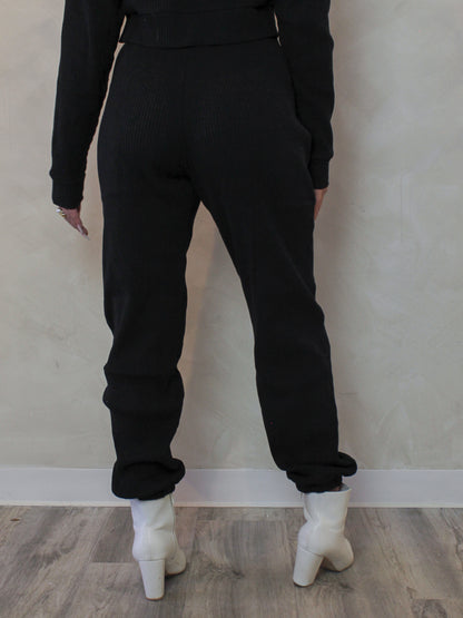 Model wearing a pair of black, ribbed, jogger sweatpants 