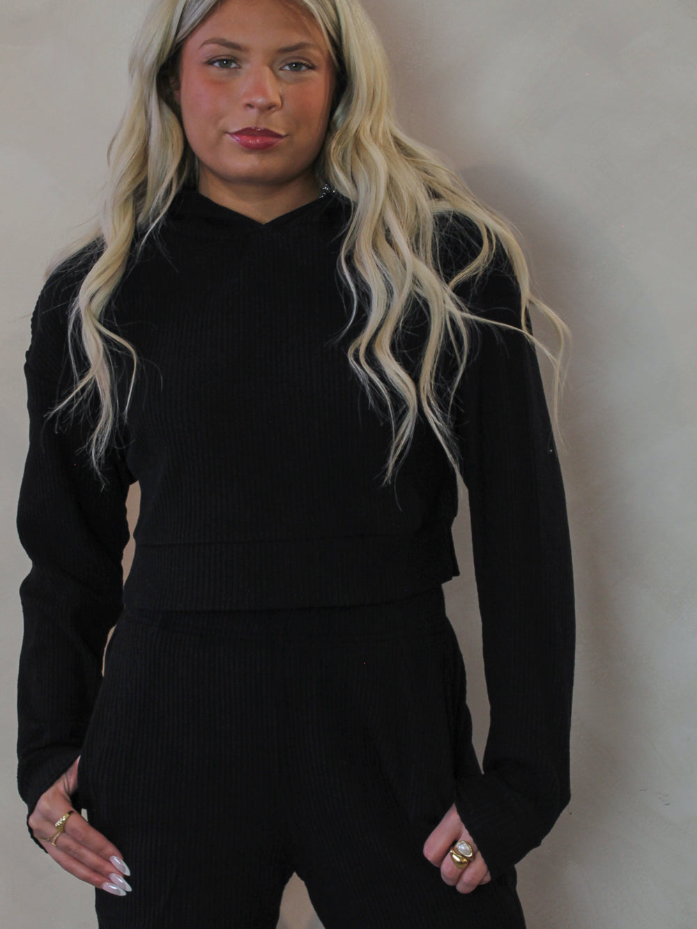 Model wearing a black, ribbed, lounge top with matching black pants 