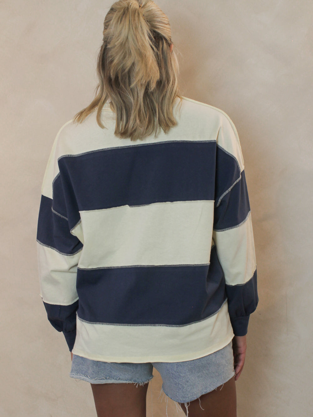 Back view of a Model wearing a blue and white stripe top 
