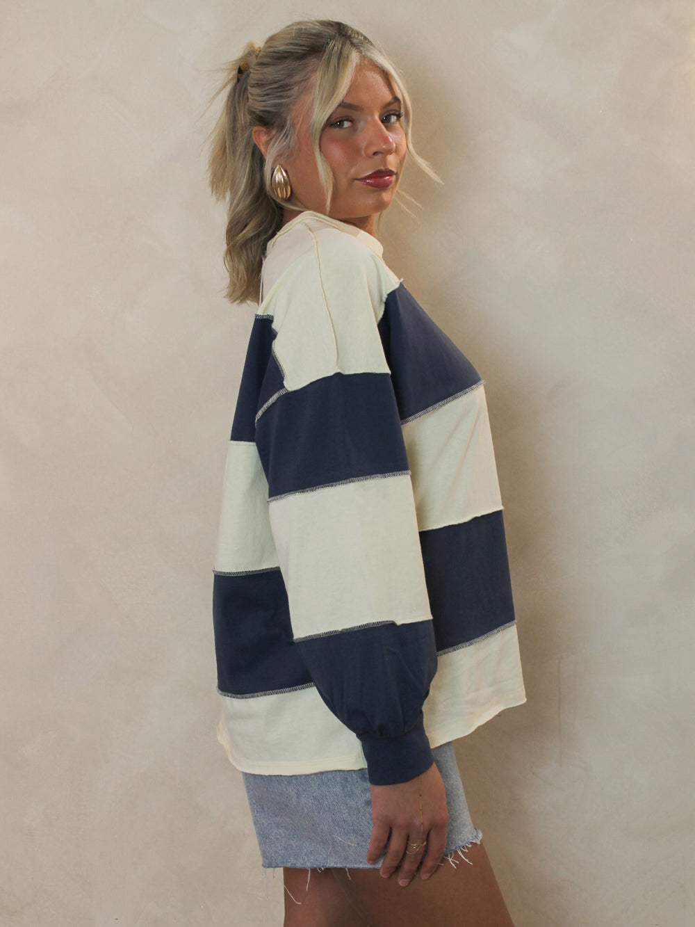 Model wearing a blue and white stripe long sleeve top 
