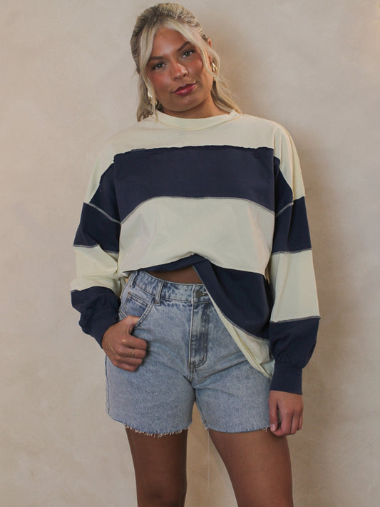 Girl wearing a blue and cream panel long sleeve top 