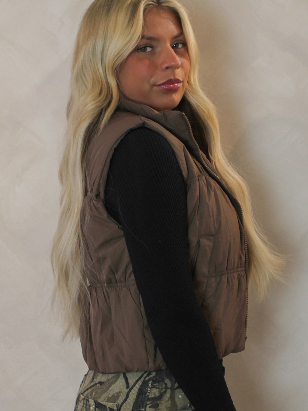 Model wearing a brown cropped puffer vest 