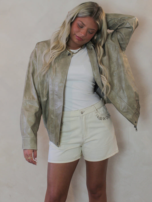 Model wearing a tan faux leather jacket 