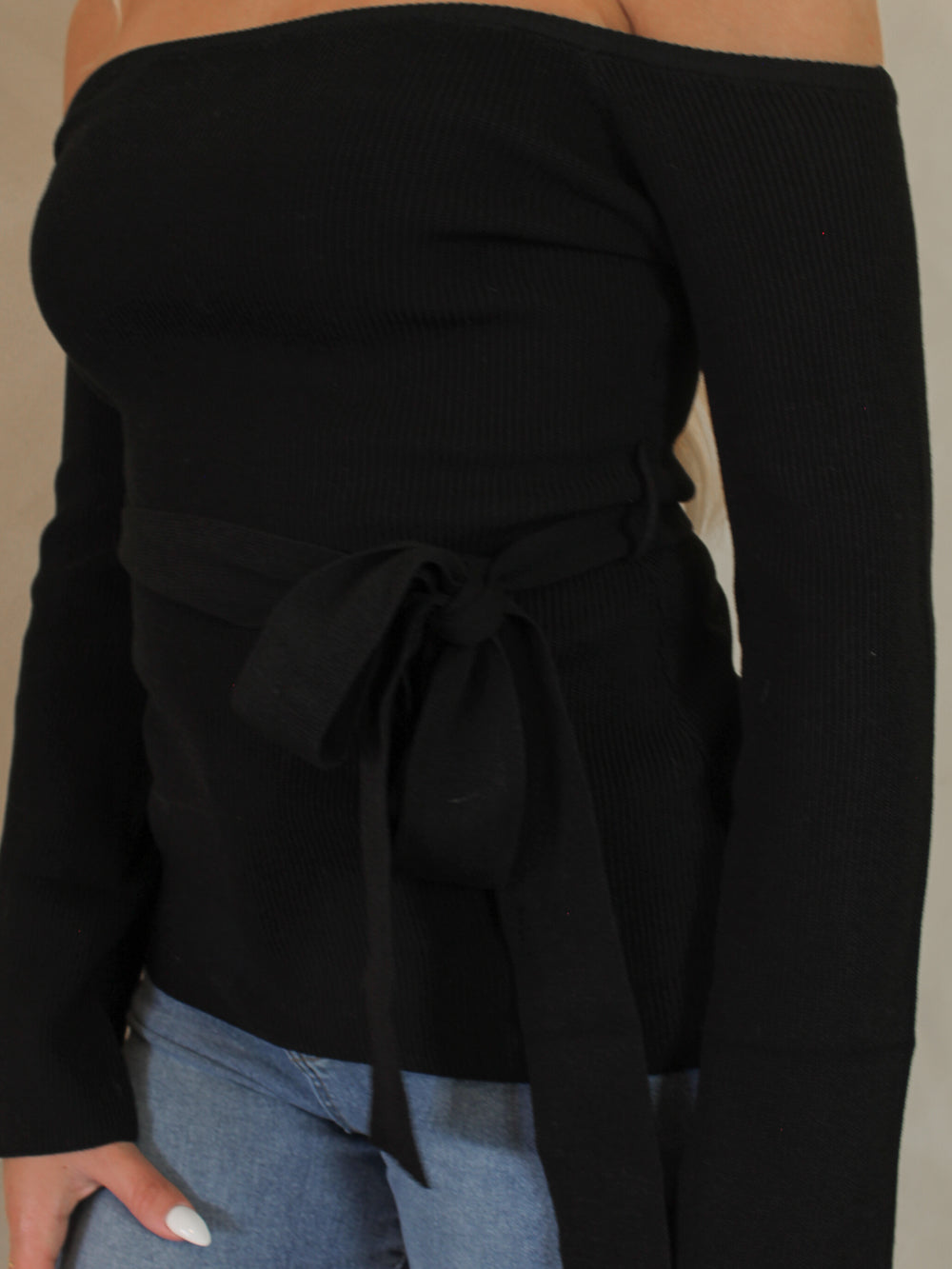 Detail of the fabric a black off the shoulder sweater 