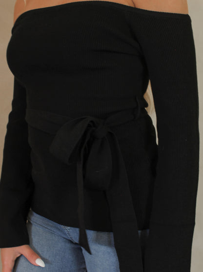 Detail of the fabric a black off the shoulder sweater 