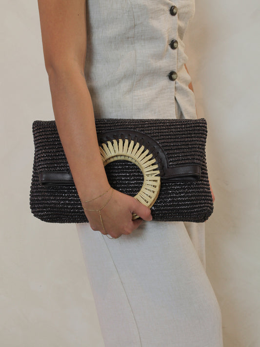 Chocolate brown woven clutch with a rattan handle 
