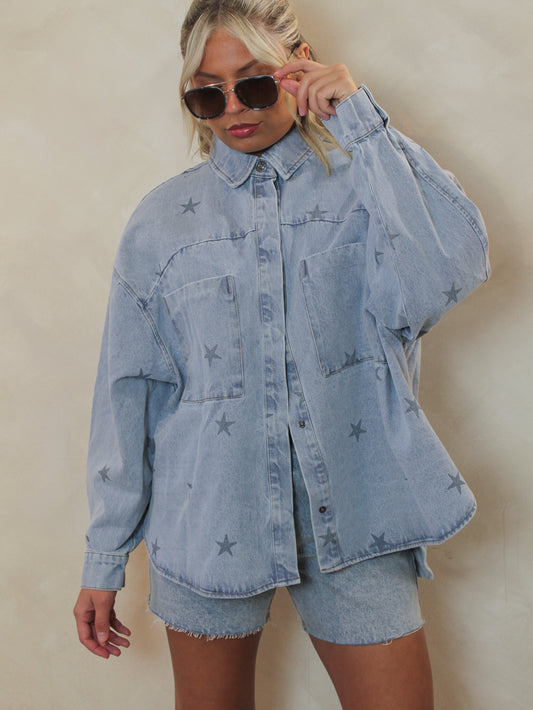 Girl wearing a denim, long sleeve top paired with denim shorts, sunglasses and gold accessories outfit 