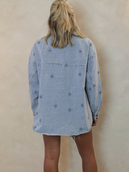 The back view of a girl wearing a long sleeve denim top with an all over star print 