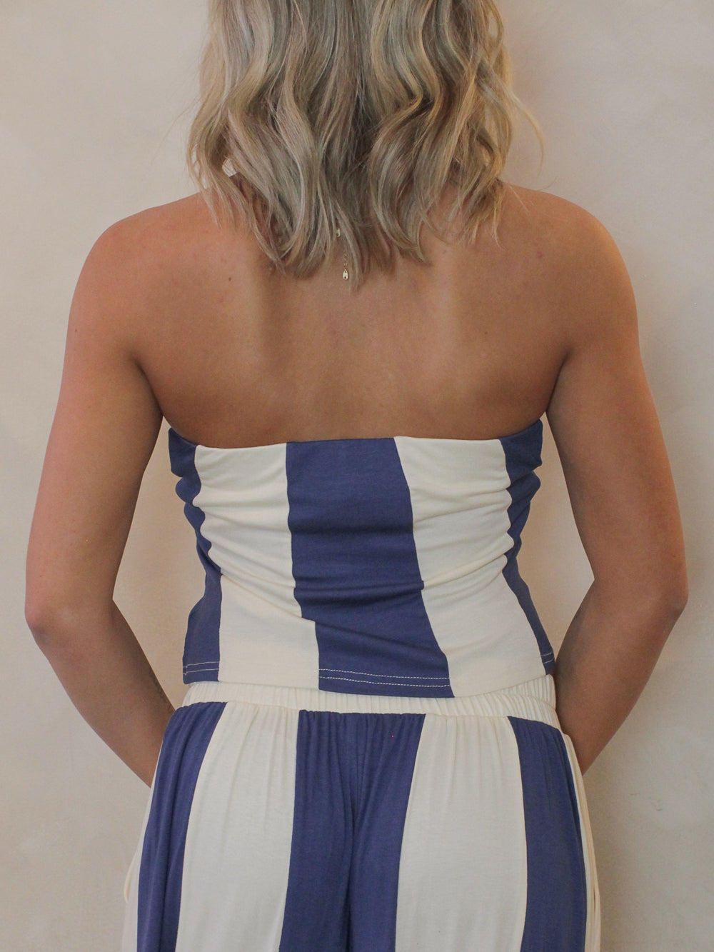 Woman wearing a blue and cream strapless top - back view
